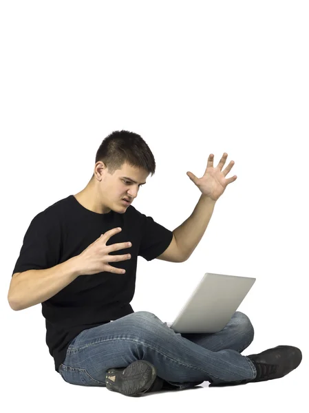 Сердитий хлопець-підліток дивиться на свій ноутбук — стокове фото