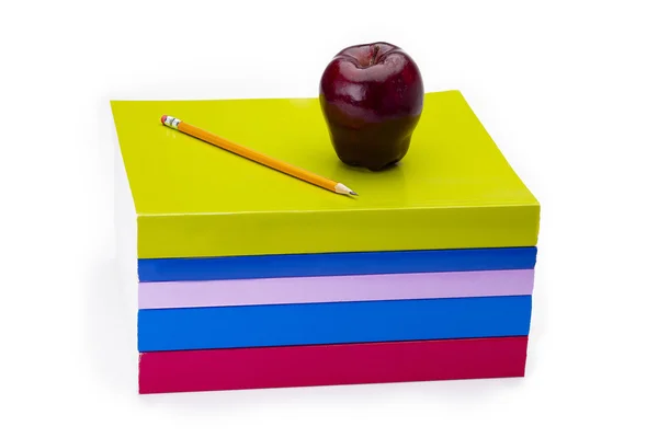 Jabłko i ołówek, siedząc na stos książek — Zdjęcie stockowe