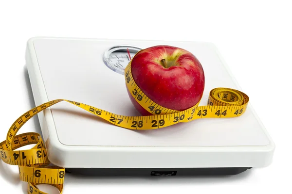 Manzana con cinta métrica en escala de peso — Foto de Stock