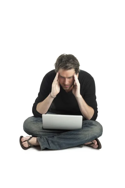 Annoyed man using a laptop — Stock Photo, Image