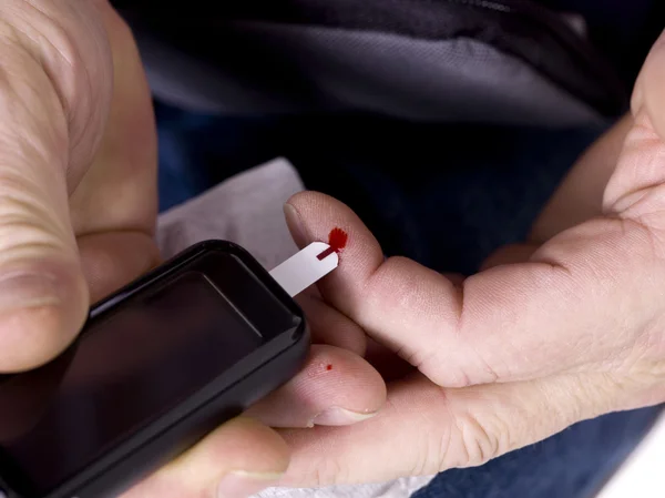 A man measuring his blood sugar — Stock Photo, Image