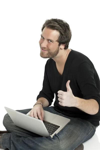 En man gestikulerande godkänd innehar en laptop — Stockfoto