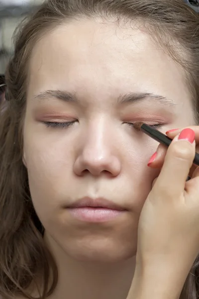 Una dama aplicando sombra de ojos — Foto de Stock