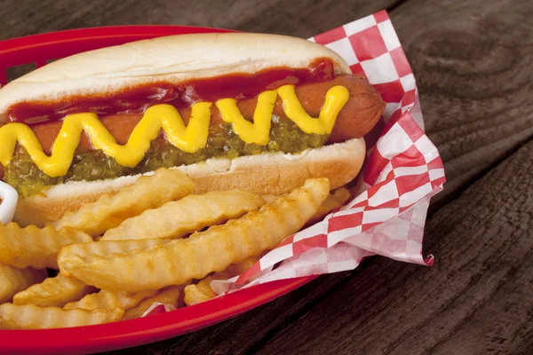 Een plaat met hotdog broodje en aardappel frietjes — Stockfoto