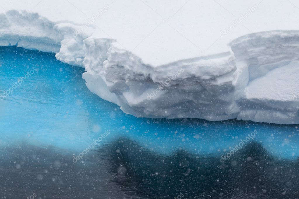 Snow falling on iceberg ledge