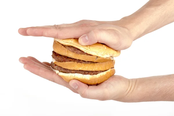 Рука, нажимающая на гамбургер — стоковое фото