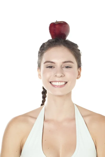 Nainen hymyilee omena päässään. — kuvapankkivalokuva