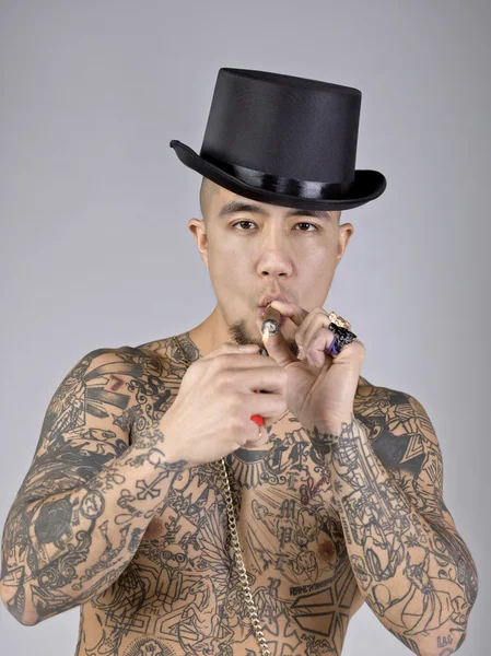Um homem com tatuagem fumando um cigarro — Fotografia de Stock