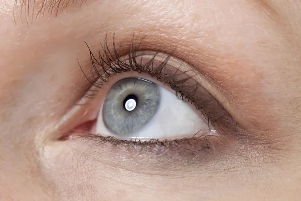 Un ojo de mujer mirando hacia arriba — Foto de Stock