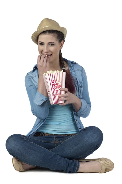 A woman on the floor eating popcorn — Stock Photo, Image