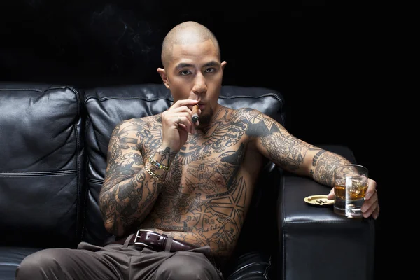 African american mafia boss smoking a cigar while having whiskey — Stock Photo, Image