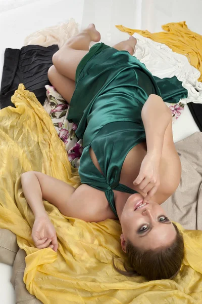 Lockande kvinna liggande på kläder — Stockfoto