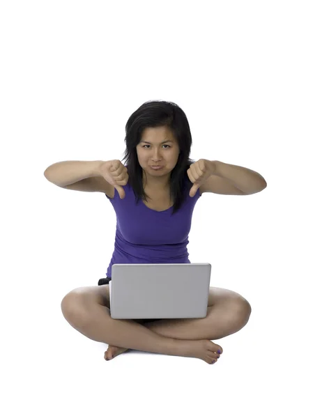 Asian woman showing thumbs down while using laptop — Stock Photo, Image