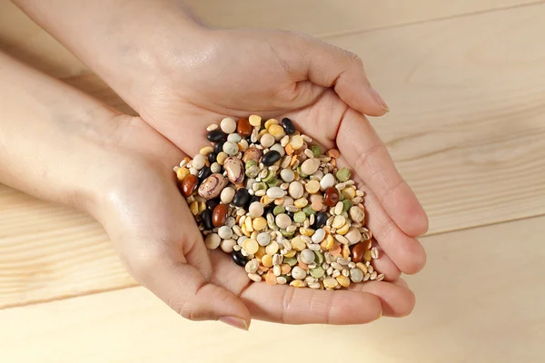 Assorted beans in human hands — Stock Photo, Image