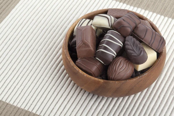 Ciocolată asortată în castron de lemn — Fotografie, imagine de stoc