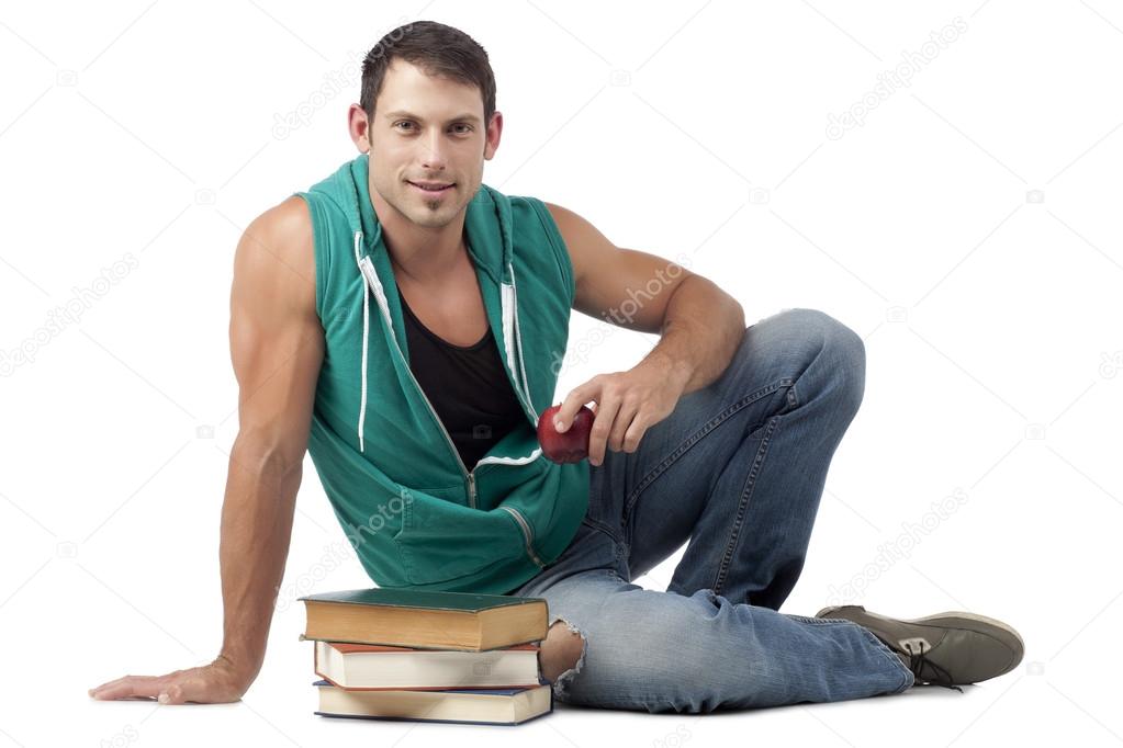 attractive guy holding red apple with books