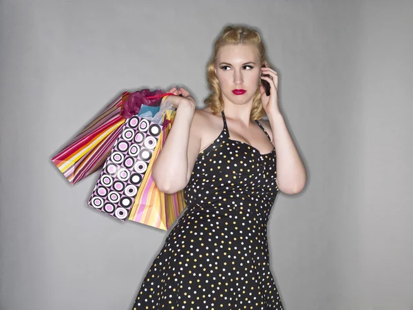 Senhora atraente com sacos de compras e celular — Fotografia de Stock