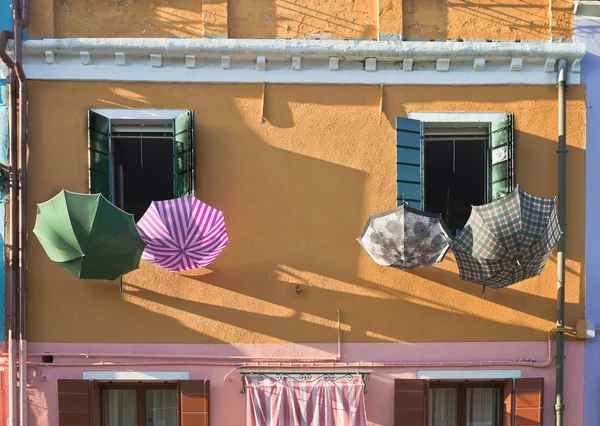 Gelbe Wand mit den Regenschirmen. Burano Insel. Venedig. — Stockfoto