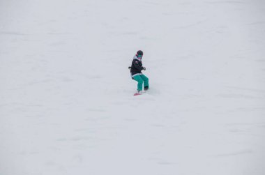 # Kız kayağa biniyor Dağın yamacından aşağı #