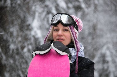 Dağlarda, ormanda kar yağışı olan bir kız.