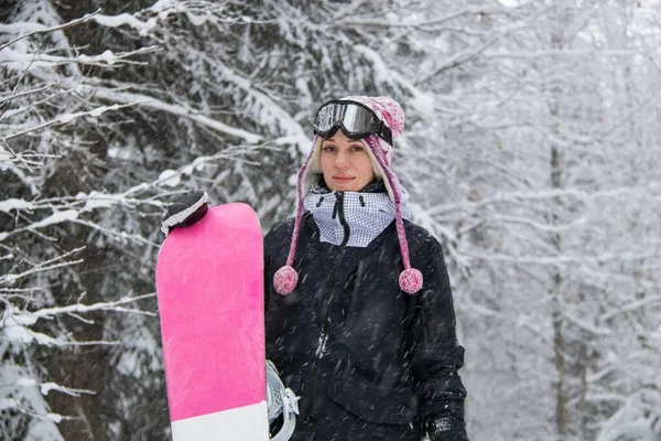 Lány hódeszkával az erdőben a hegyekben és a hóesésben — Stock Fotó