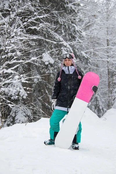 Gadis dengan papan salju di hutan di pegunungan dan salju — Stok Foto