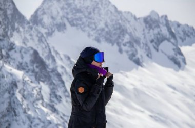 Karlı bir dağın tepesinde bir kızın portresi.