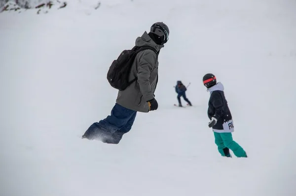 Snowboardcular dağın yamacından aşağı iniyor. — Stok fotoğraf