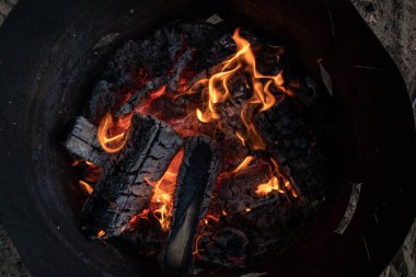 Eski bir demir fıçıda turuncu bir alevin üst görüntüsü