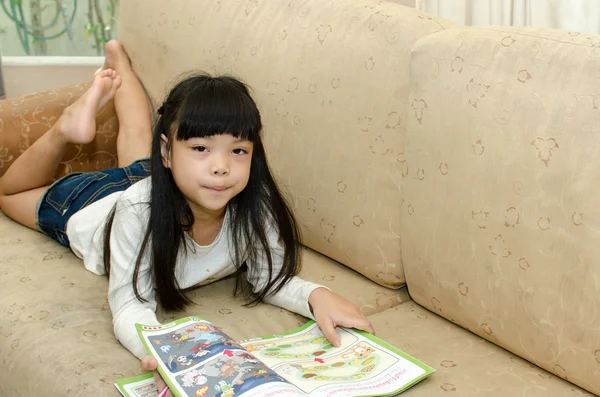 Girl writing on the sofa — Stock Photo, Image