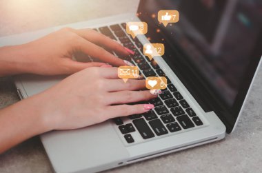 Kadın internet pazarlaması için dizüstü bilgisayar sosyal medya kullanıyor. Bildirim simgelerine sahip iş teknolojisi kavramı, mesaj, e-posta, yorum