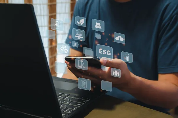Sustainable business concept (Environmental, Social, Governance: ESG).Hand holding phone icon business virtual on screen background.