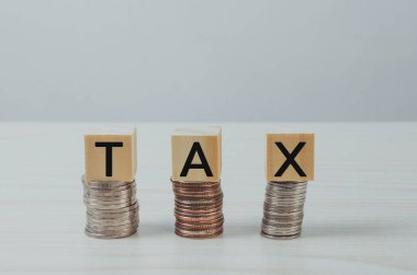 Bozuk para simgesi üzerine tahta küp bloğu Vergi işletmesi finans kavramı.