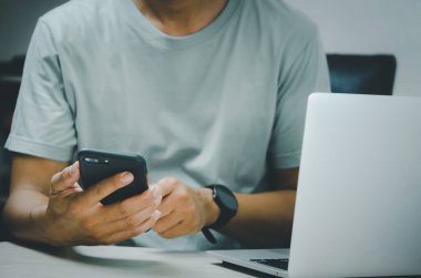 Adam elinde akıllı telefon ve bilgisayarla internet arama, mesaj gönderme, mesajlaşma veya internet bankacılığı gibi teknolojileri kullanıyor..