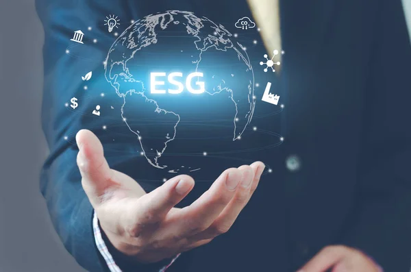 İnsan eliyle sanal dünya ikonu. ESG Çevre Sosyal Yönetimi simgeleri ve sembolleri sanal ekranda. İş konsepti.