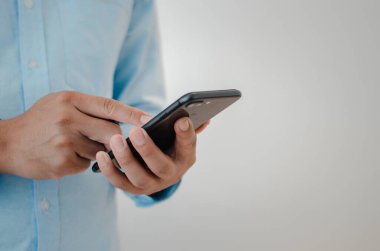 close up man hand holding mobile smartphone copy space.person texting text message internet technology concept.