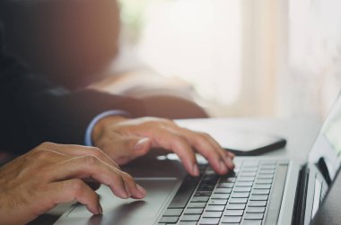 Dizüstü bilgisayarı kullanarak klavyeye yakın çekim yapan bir iş adamı. Online iş. - İnternet. Ofiste araştırma raporu hazırlanıyor.