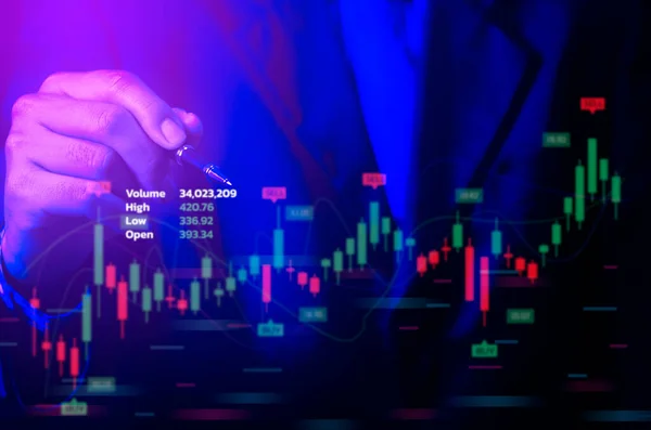 Man pointing with hand at graph of stock market financial exchange statistics and business chart of digital metaverse technology with growth economy concept.