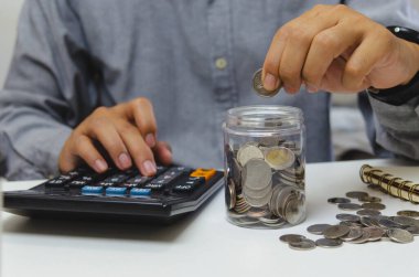 male businessman use calculator money coin financial tax and planning investments marketing economy income and retirement saving.