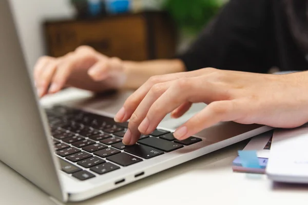 Woman hand using keyboard computer laptop internet communication social network digital technology.