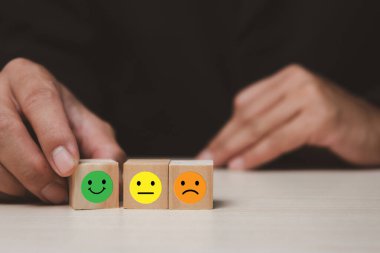 Man hand wood cube block emotion service and customer review feedback rating good on table.