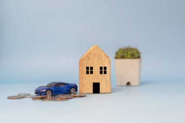 Plan finances investments and savings to buy house real estate and cars.Money coin and car and home on table business accounting and tax and insurance concept.