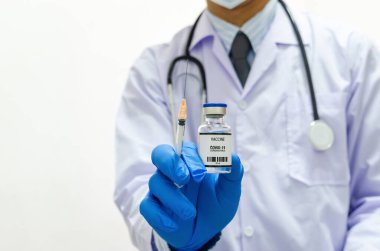 Male doctor wearing uniform medical gloves holding a bottle of covid 19 vaccine virus on white background.copy space.