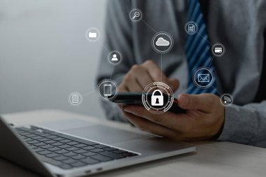 Elinde akıllı telefonla çalışan bir iş adamı. Sanal ekranda parlayan kilit simgeleriyle siber güvenlik hologramı. İnternet ve ağ teknolojisi konsepti