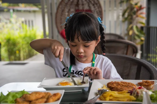 Niña Asiática Comer Frito Huevo Plato Mesa —  Fotos de Stock