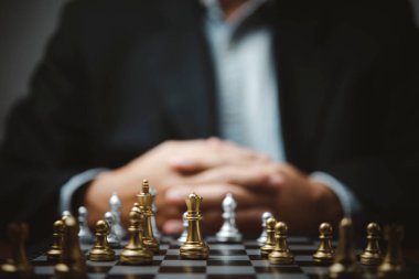 Stratejik planlama ve hedefler başarılı iş fikri. Satranç tahtasına bakan bir iş adamı.