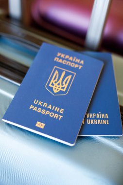Ukrainian passports lie on suitcases waiting for a flight to another country. Two passports of the same family