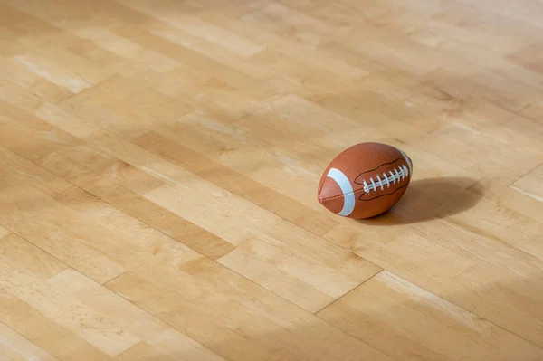 天然照明付きの堅木張りの床のアメリカのサッカーボール ワークアウトのオンラインコンセプト 水平スポーツポスター グリーティングカード ヘッダー ウェブサイト — ストック写真