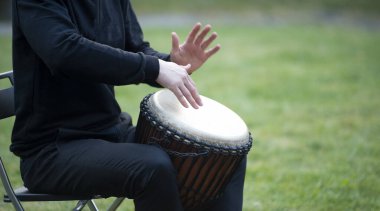 Afrikalı bir djembe davulda çalan bir müzisyenin elleri