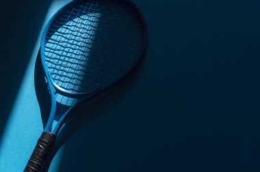 Mavi arka planda doğal ışıklandırması olan beyaz profesyonel tenis raketi. Yatay spor temalı poster, tebrik kartları, başlıklar, web sitesi ve uygulama